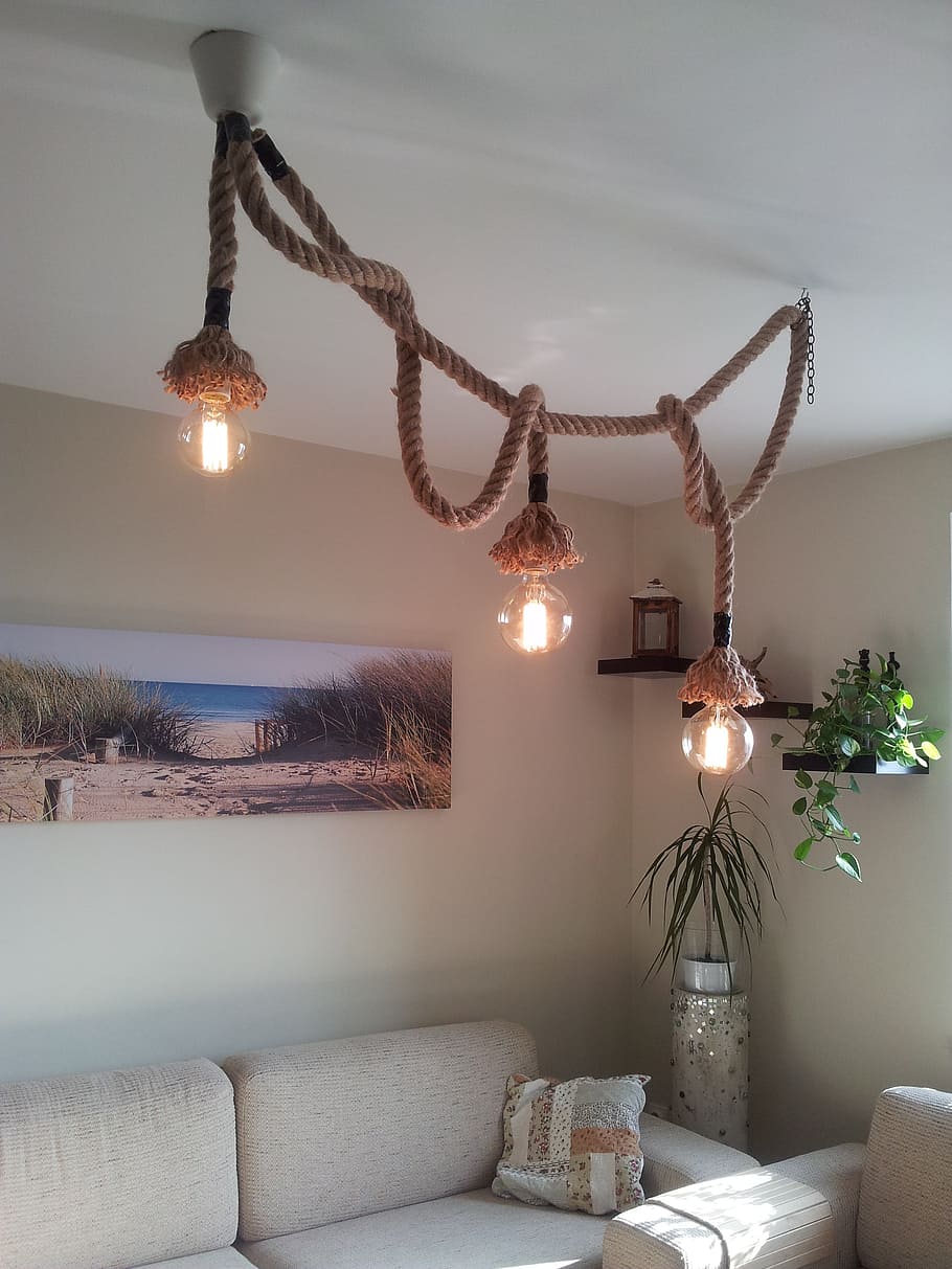 brown 3-light pendant lamp near white sofa turned-on, rope, chandelier