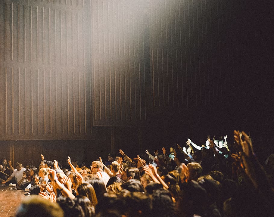 people raising their hands, group of people near stage inside building HD wallpaper