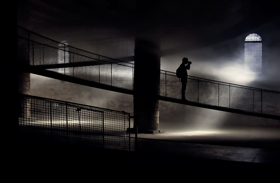 silhouette of person standing on bridge while taking photo, The photographer in the fog