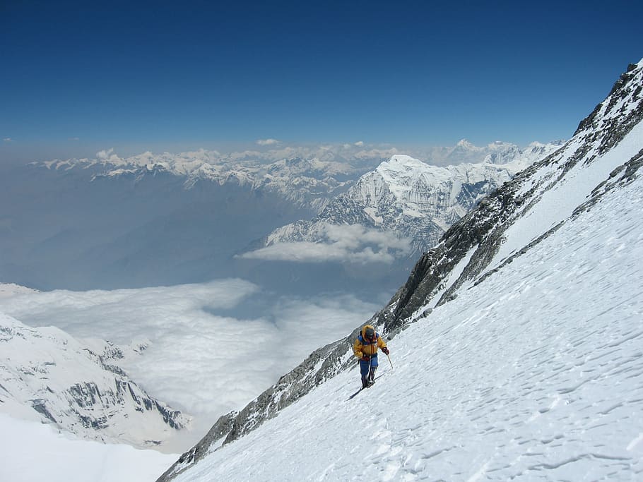 person climbing snow-covered mountain during daytime, person walking on ice mountain HD wallpaper
