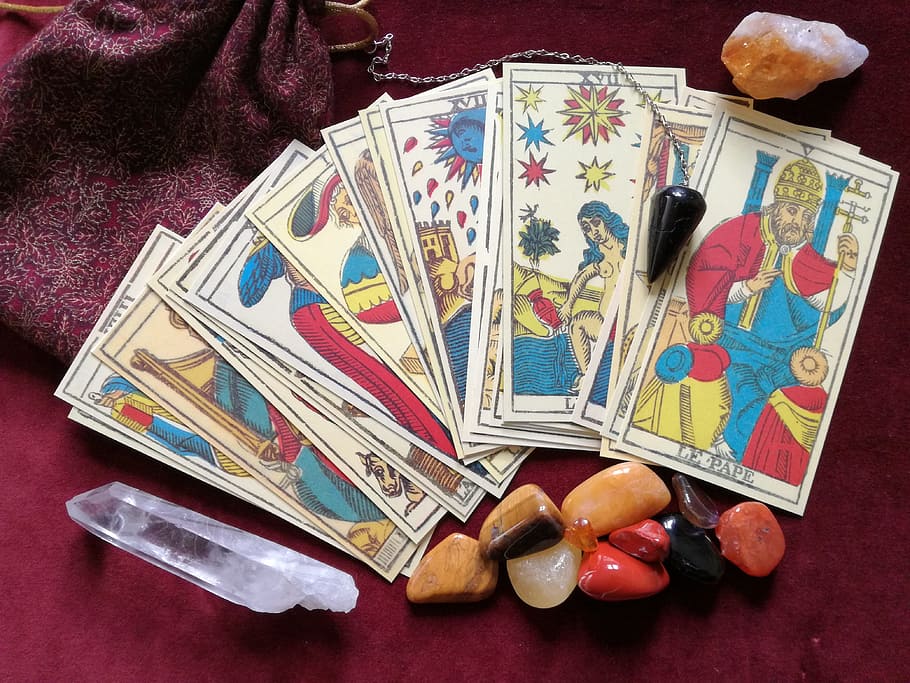 tarrot card beside stone, tarot, crystals, pendulum, occult, esoteric