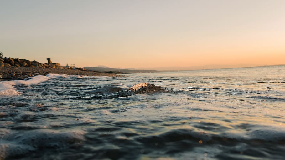 low angle photography of ocean wave at beach, low-angle photo of seawaves beside seashore HD wallpaper