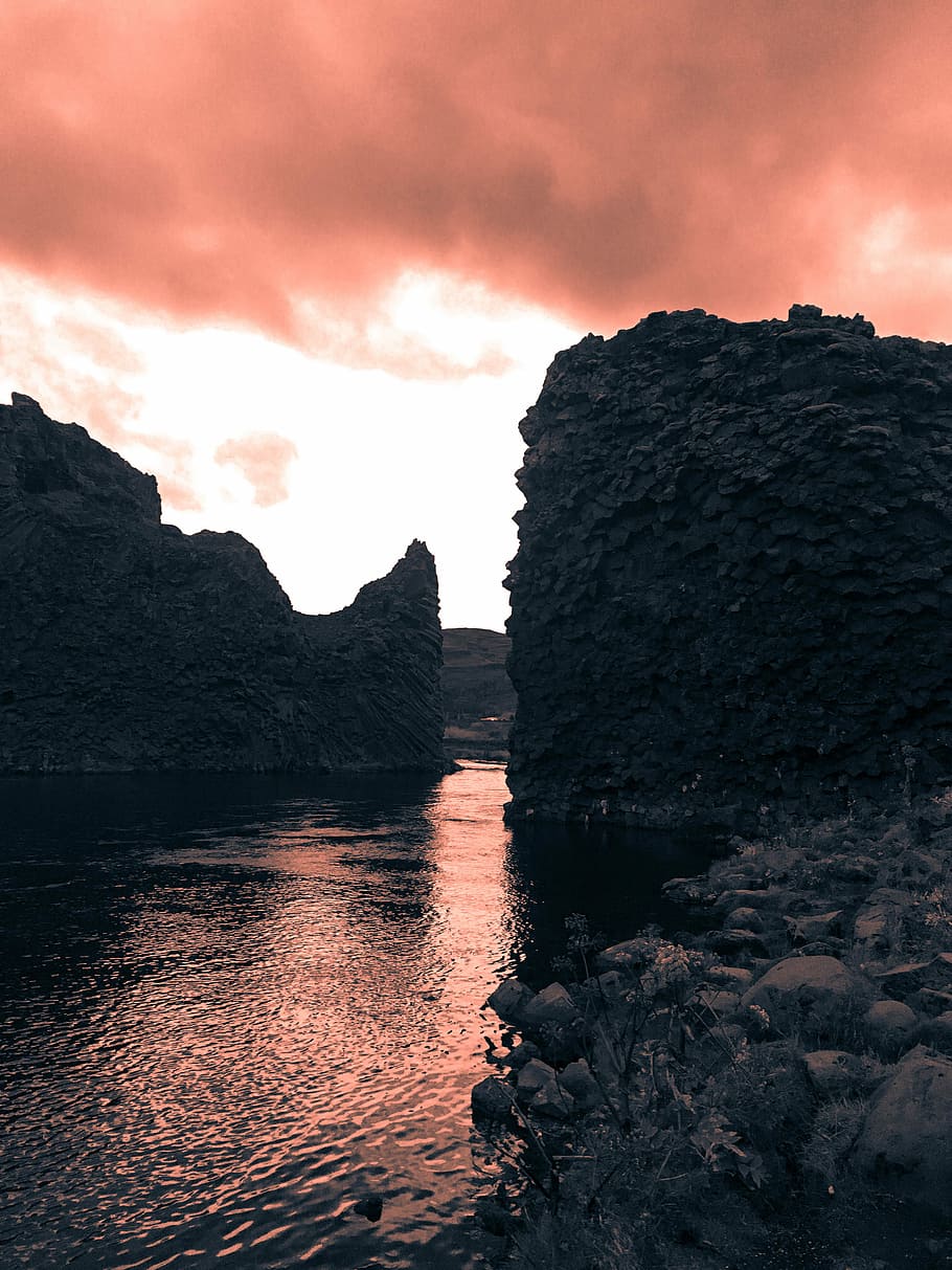 photo of body of water between cliff, calm body of water with rock formation in front HD wallpaper