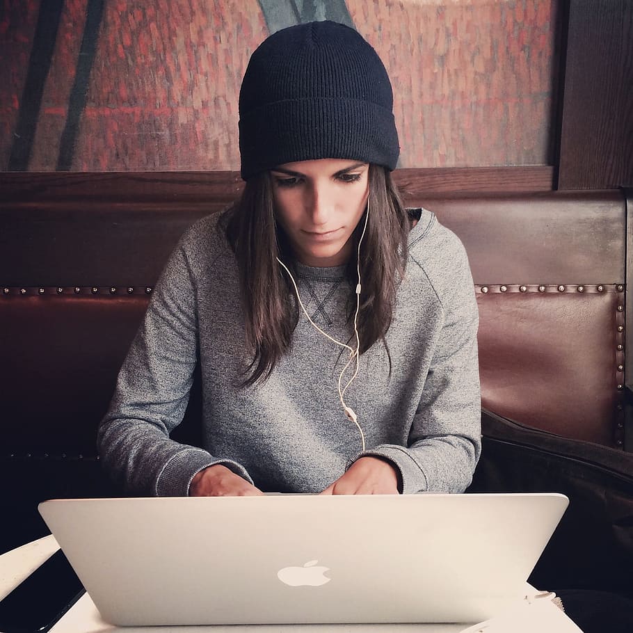 woman wearing black knit cap leaning MacBook, laptop, apple HD wallpaper
