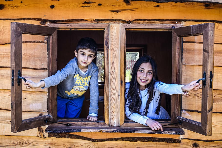 boy and girl looking holding two brown wooden window frames HD wallpaper