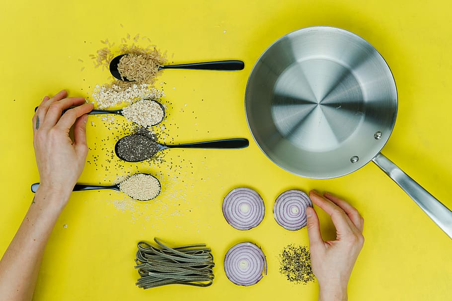 flat lay photography of saute skillet beside spoon of spices and vegetables, photography of cooking ingredients HD wallpaper