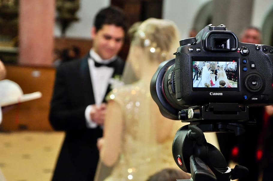 selective focus photography of camera displaying wedded couple