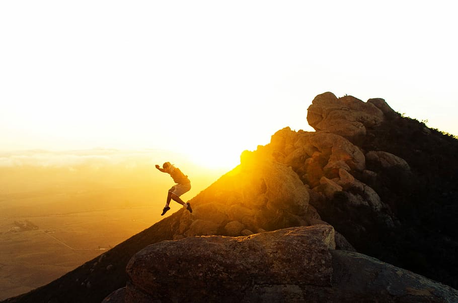 man jumping on the cliff during golden hour, man jumped on top of the mountain HD wallpaper