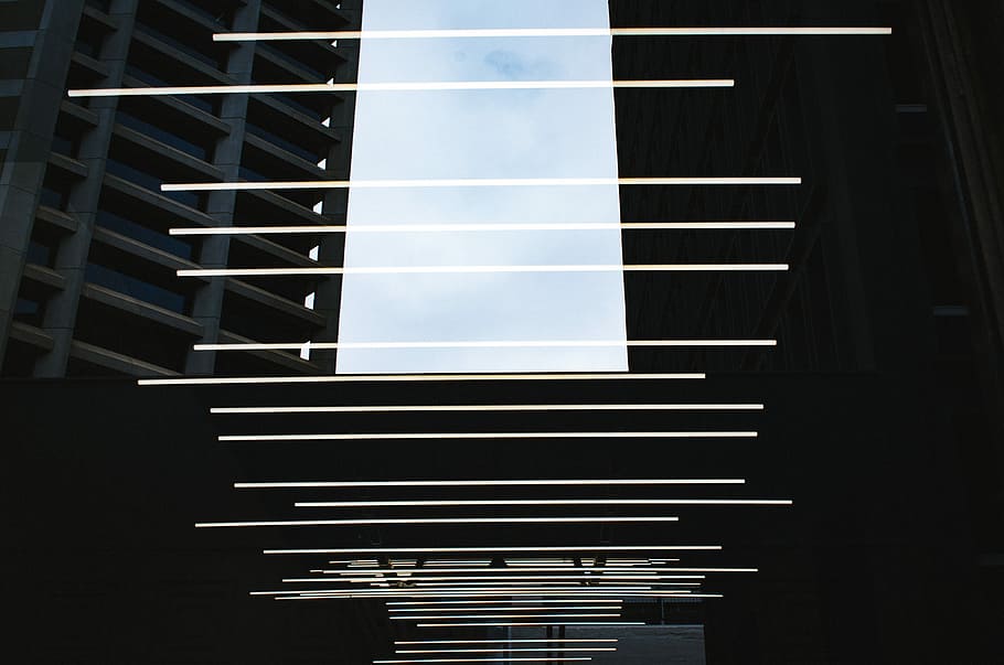 Rows of light beams above a walkway between buildings., photography of concrete buildings HD wallpaper