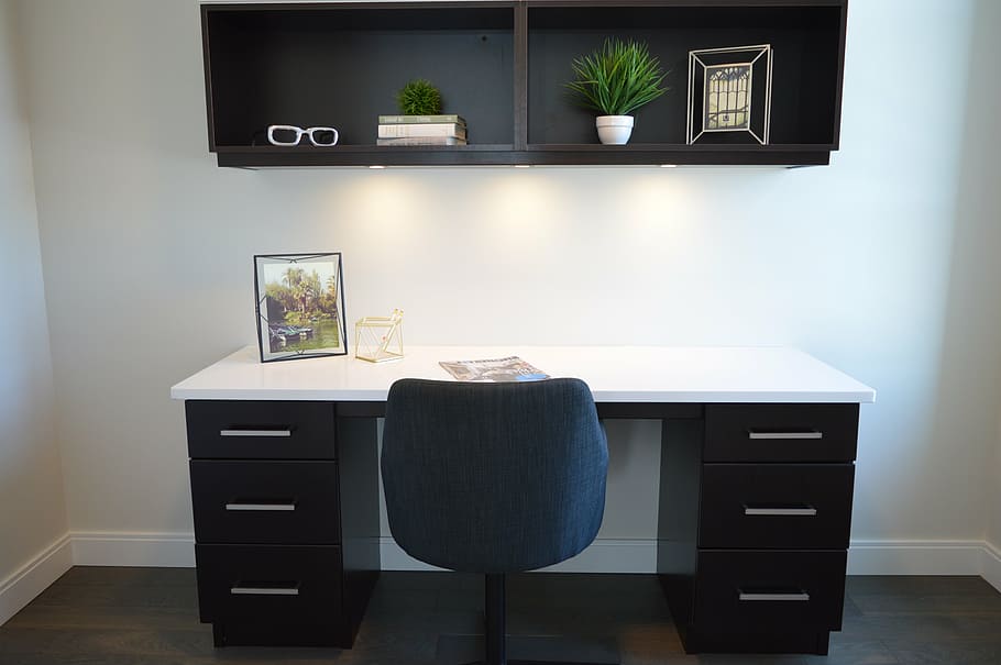 white and black wooden 6-drawer knee-hole desk with blue rolling chair