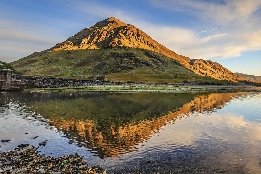 green and brown mountain beside body of water during daytime HD wallpaper