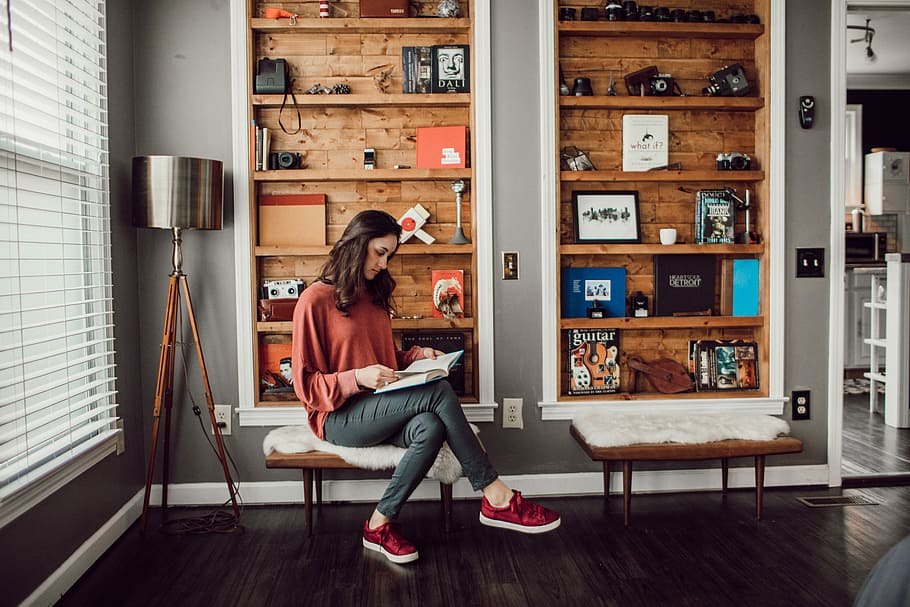 woman sitting on chair reading inside room, book, camera, person HD wallpaper