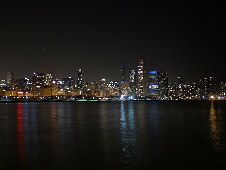 city lights across body of water during night time, chicago night