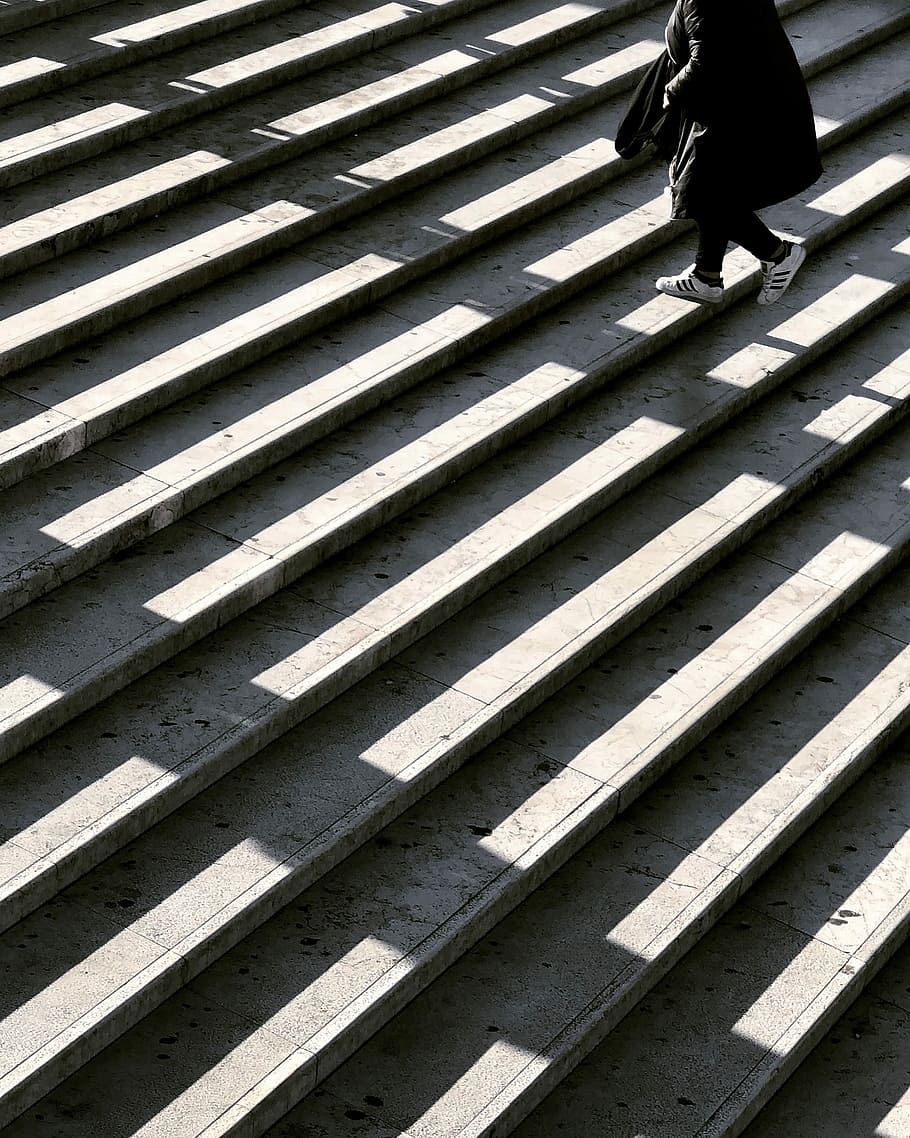 person wearing black jacket walking on stair photography, person walking on stair case HD wallpaper