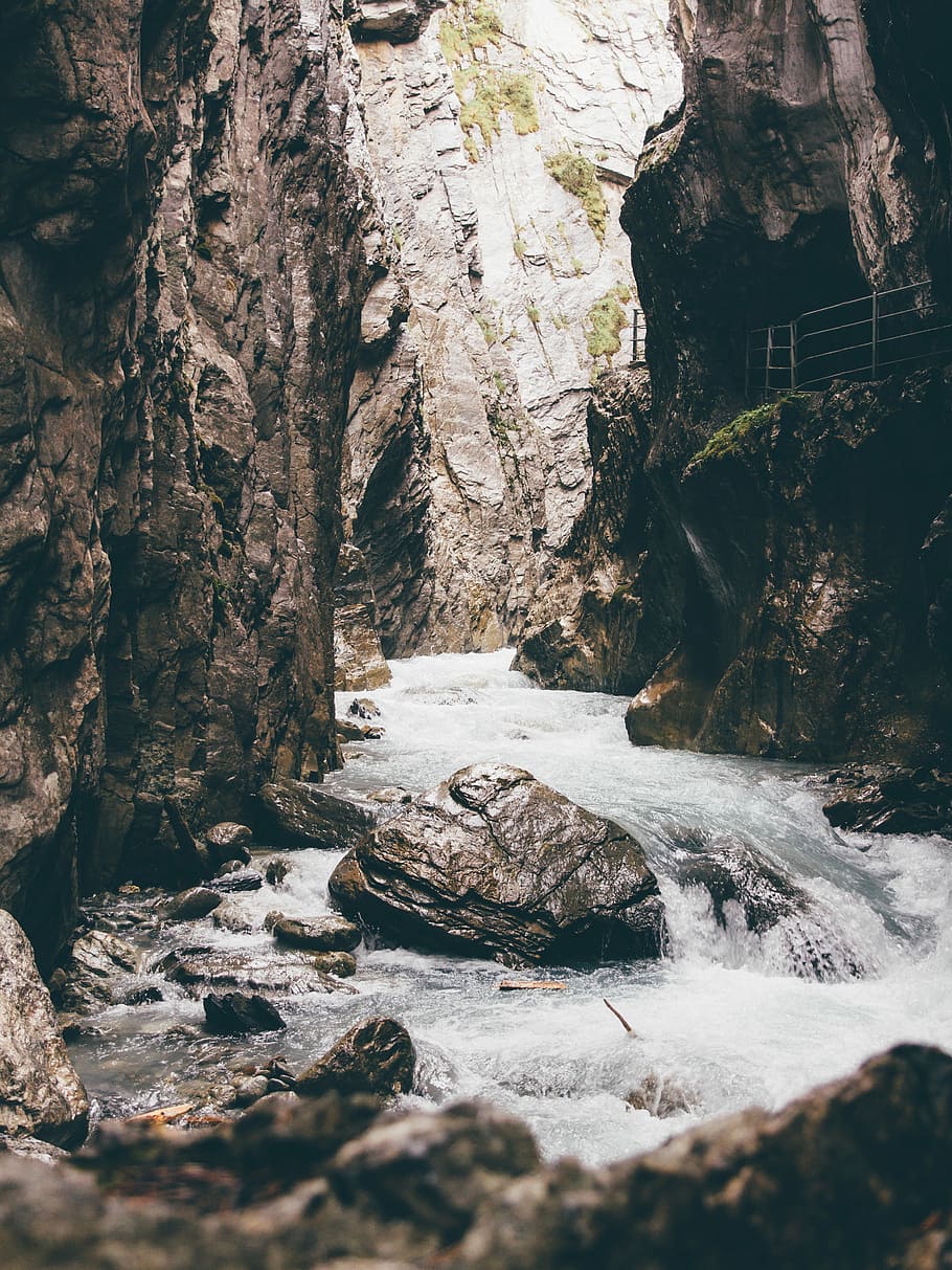 body of water beside rock formation during day time, spring river between canyon HD wallpaper
