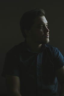 man wearing blue button-up collared short-sleeved shirt, man in blue collared top staring on his left side HD wallpaper