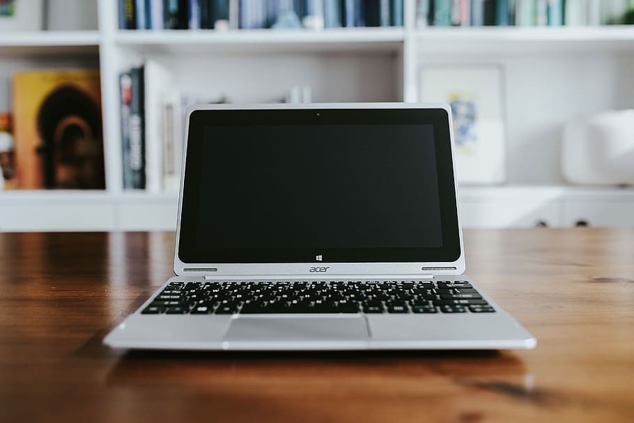 Silver laptop with various items on a table, magazines, computer HD wallpaper