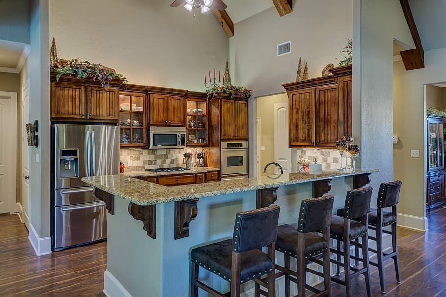 several brown wooden framed leather padded armless bar chairs in front of gray marble-top bar counter inside well lighted room