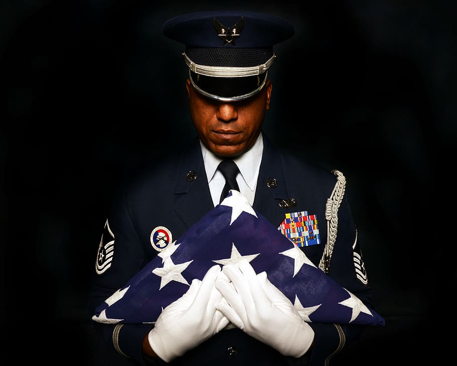person holding folded U.S.A flag, military, honor, guard, portrait