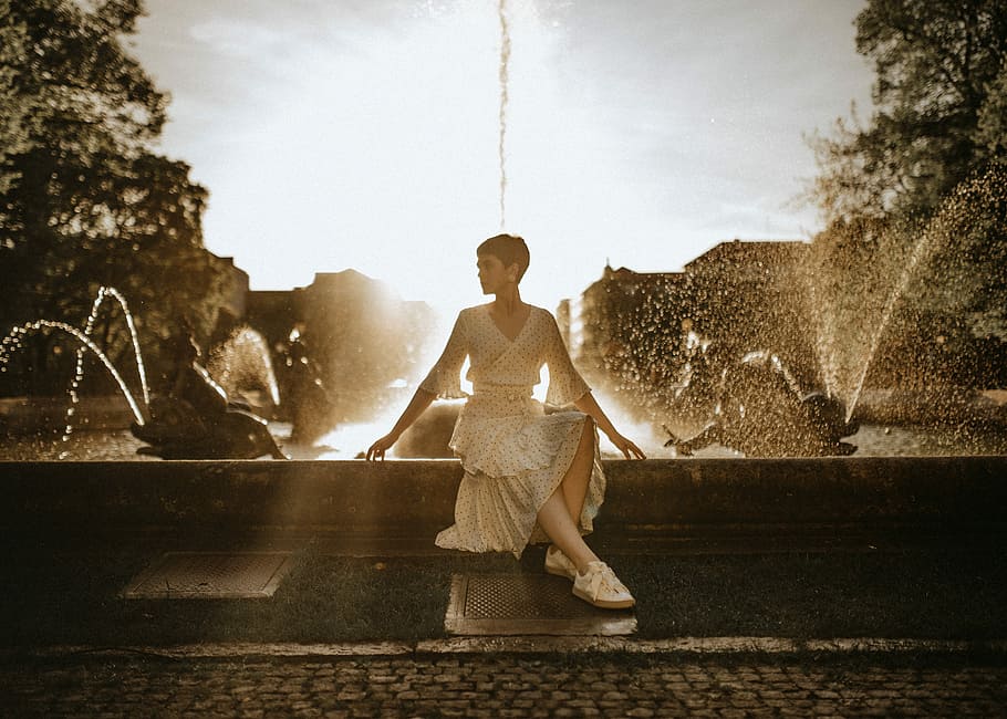 woman wearing white dress sitting near water fountain, woman wearing v-neck dress sitting beside fountain, HD wallpaper