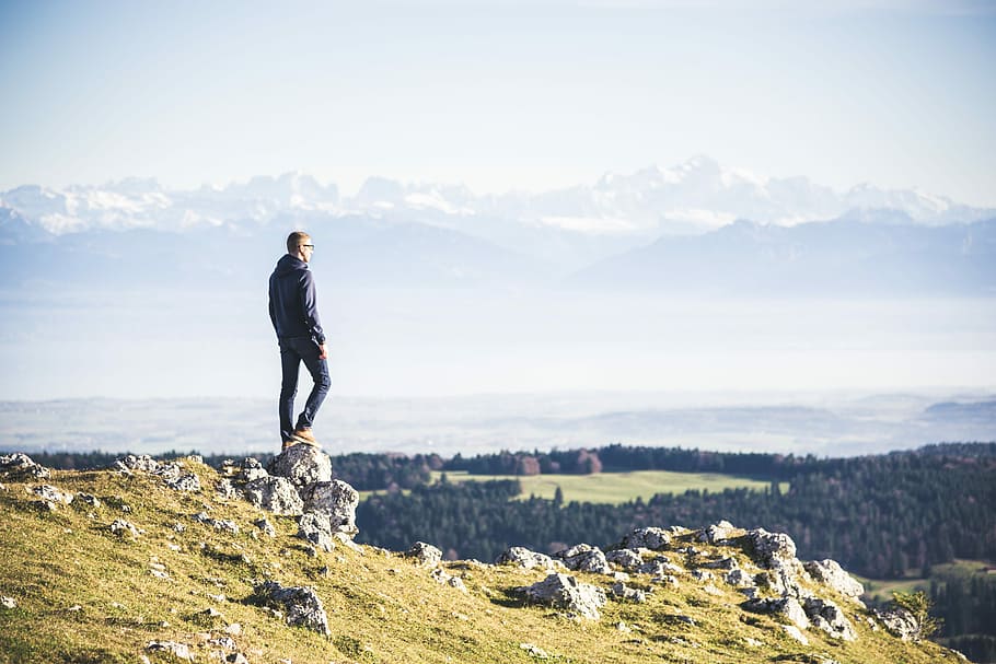 man standing on cliff, man in black jacket standing on rock, mountain HD wallpaper