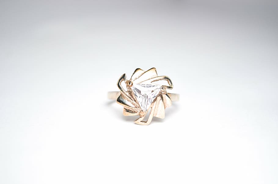 gold-colored clear gemstone encrusted ring on white surface, jewelry