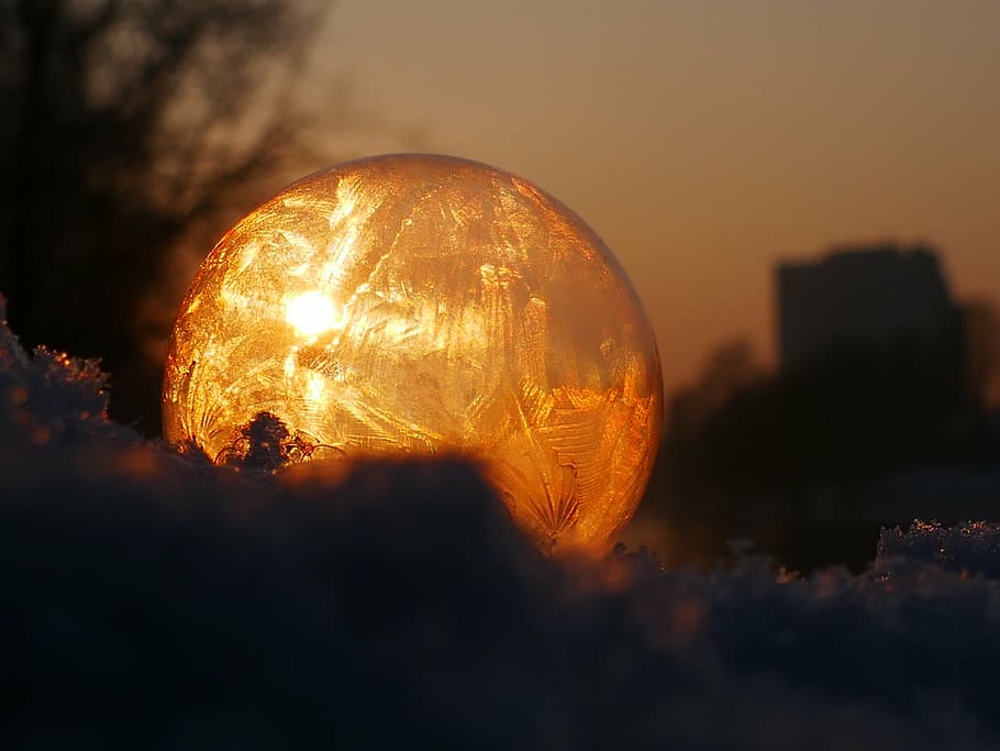 orange glass ball on ground, soap bubble, frozen, frost, winter