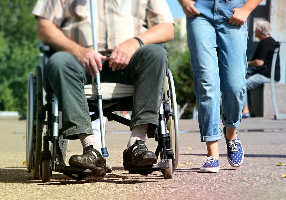 man siting on wheelchair beside person in jeans, disabled, pram