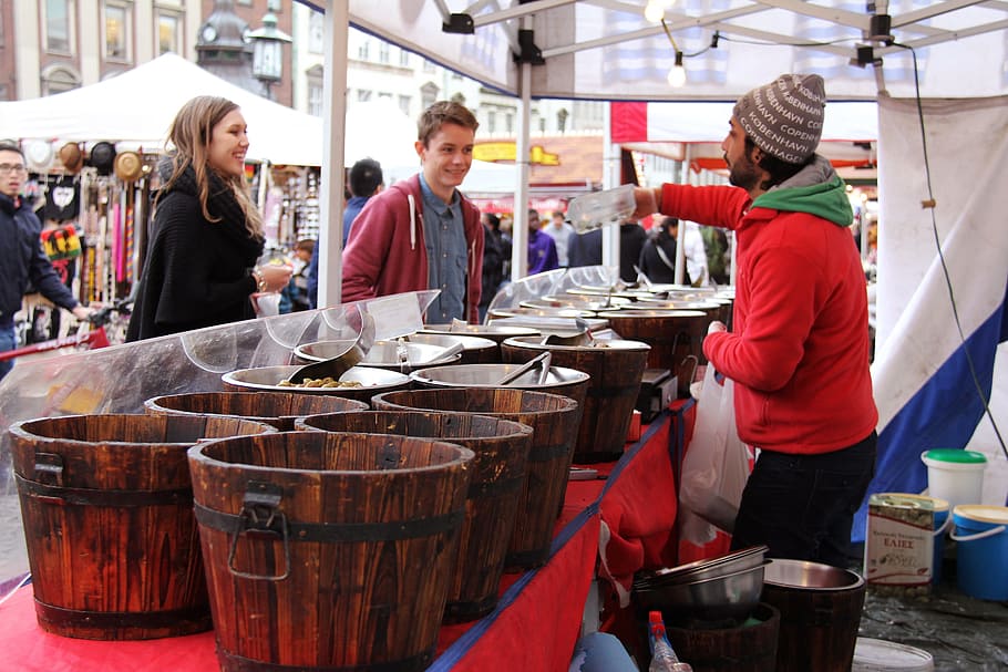 man standing near wooden buckets, food, fair, sweets, nuts HD wallpaper