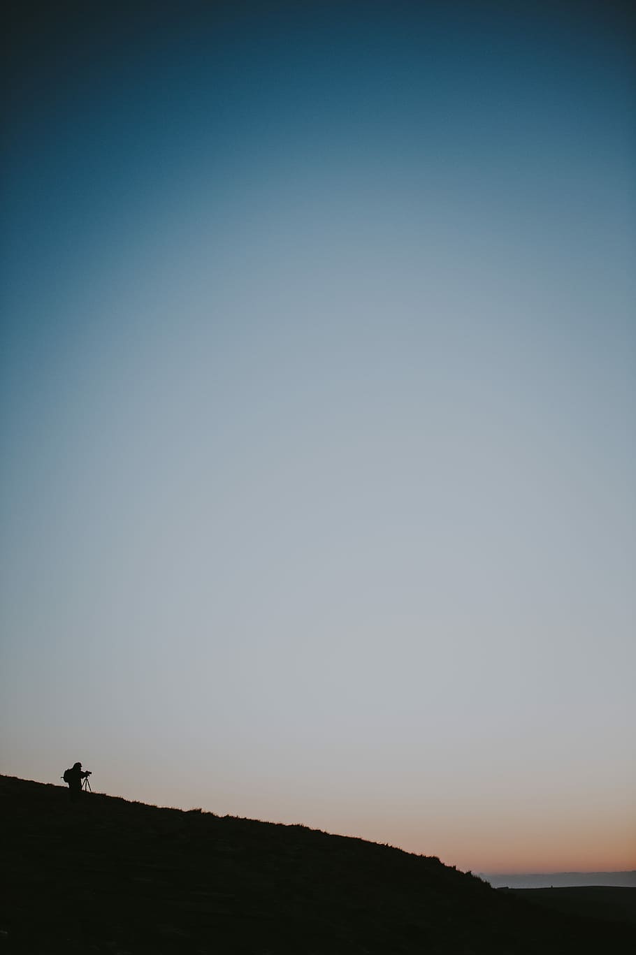 Photographer silhouette, person on mountain under golden hour HD wallpaper