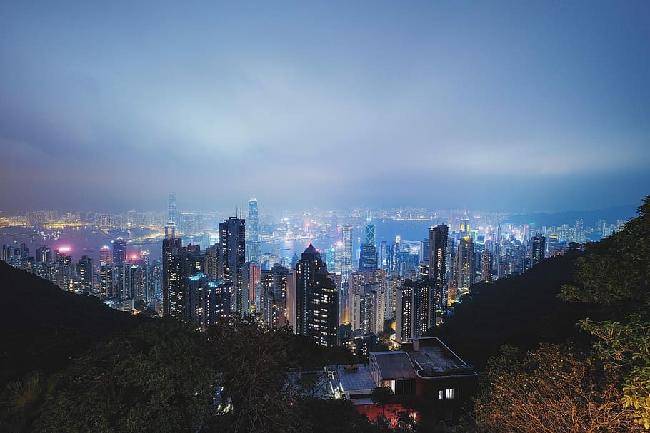 aerial photography of cities during night time, aerial view of lighted buildings beside mountain HD wallpaper