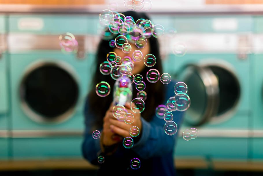woman playing bubbles, selective focus photography of girl blowing bubbles, HD wallpaper