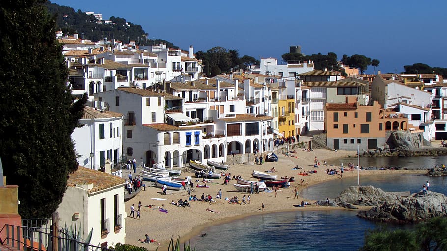 group of people near body of water and houses, calella, calella de palafrugell