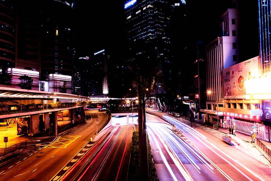 time lapse photography of passing vehicles between high-rise buildings, city at night HD wallpaper