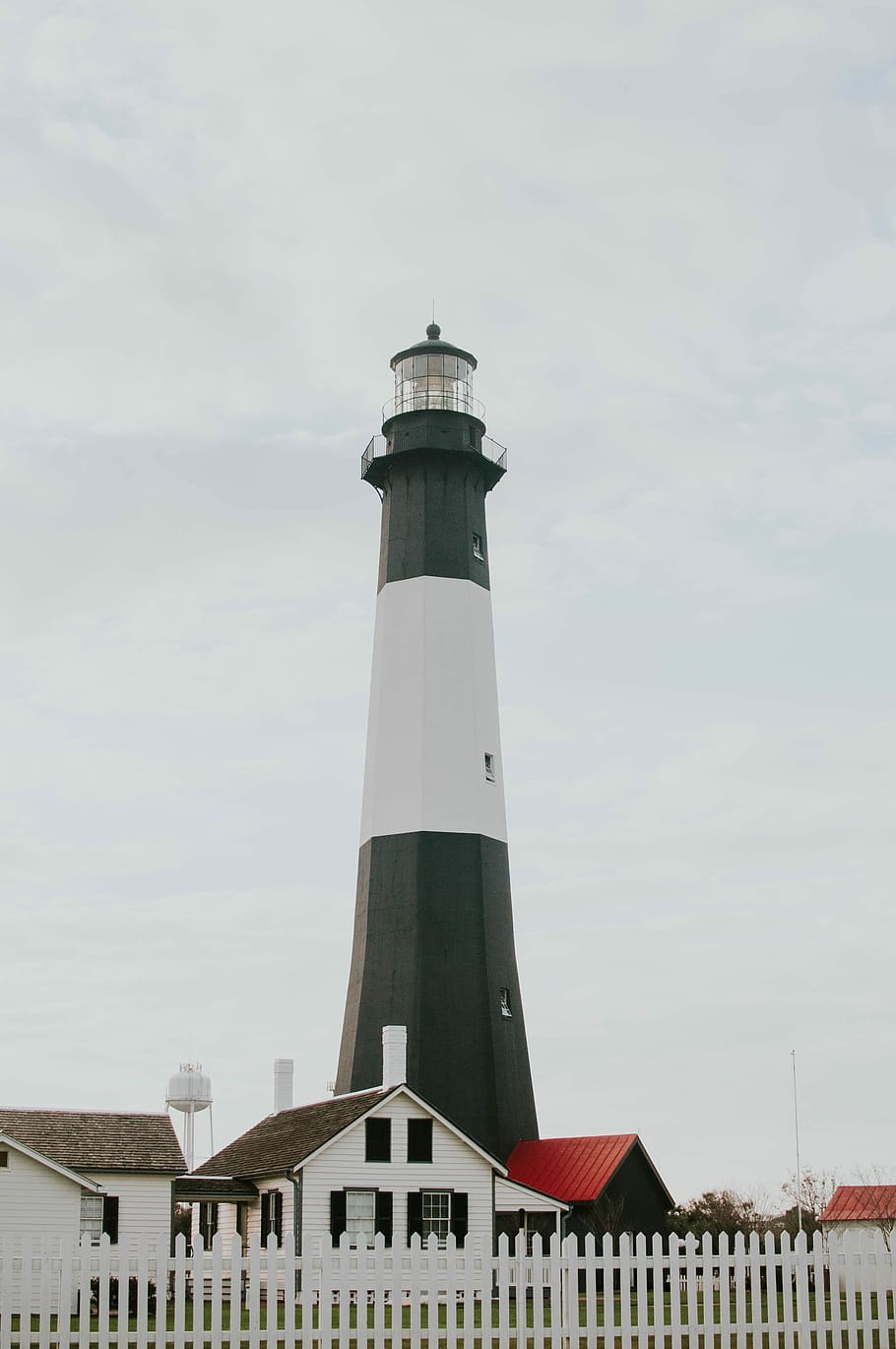 black and white lighthouse low-angle photography at daytime, white and black lighthouse near beside white and red house under white cloud, HD wallpaper