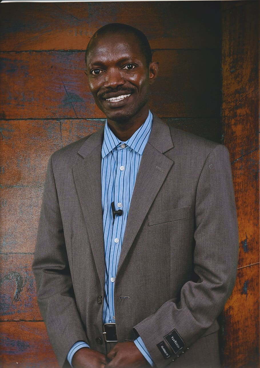 man wearing gray and blue suit smiling, author, advocate, speaker