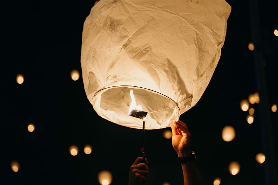 person holding sky lantern at night, view of sky lantern at night HD wallpaper