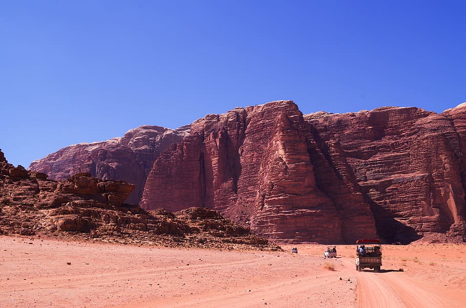 group of people traveling to desert field near to mountain, photo of vehicle near cliff HD wallpaper