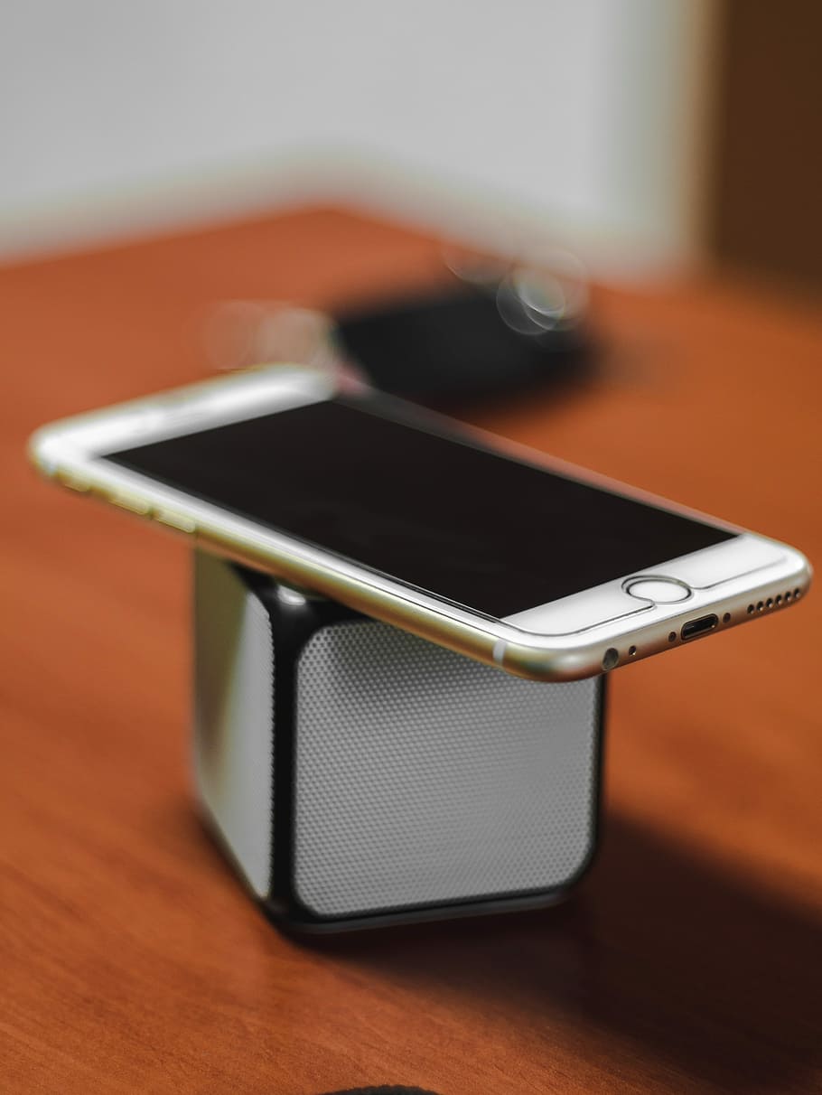 gold iPhone 6 on top of Bluetooth portable speaker, gold iPhone 6 on white and black Bluetooth speaker HD wallpaper
