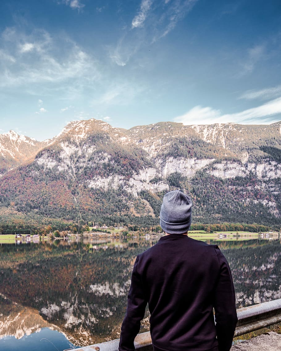man wearing blue knit cap, person wearing gray beanie standing near mountain HD wallpaper