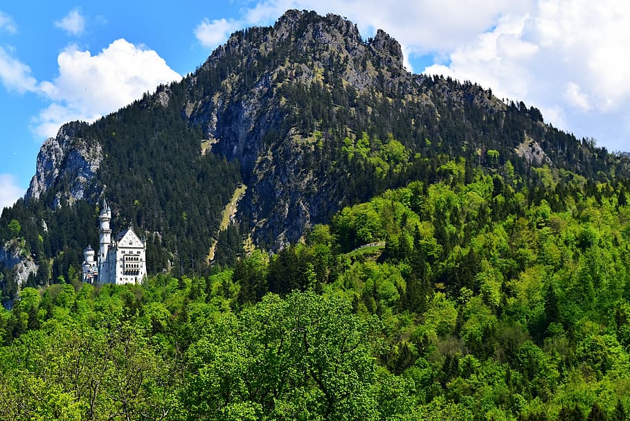 white concrete building on mountain, green and black high mountain under blue and white sky at daytime HD wallpaper