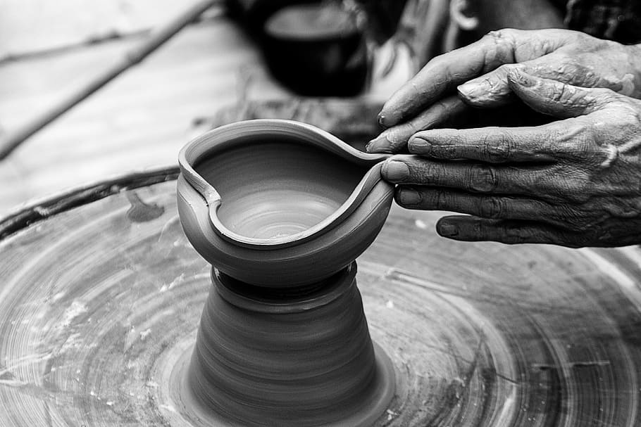 person's hand molding clay vase, black and white, nails, hands