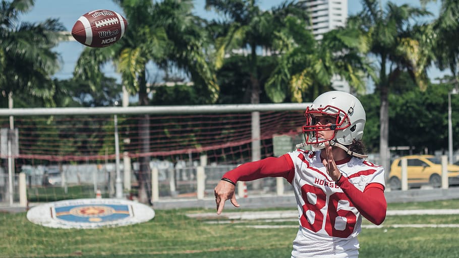 football player throwing footbal, man wearing red and white 86 football jersey throwing football HD wallpaper
