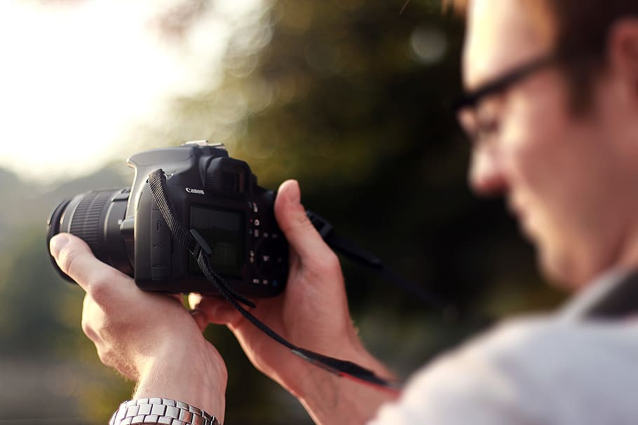 Person Holding Camera during Day Time, canon, dslr, hands, man HD wallpaper