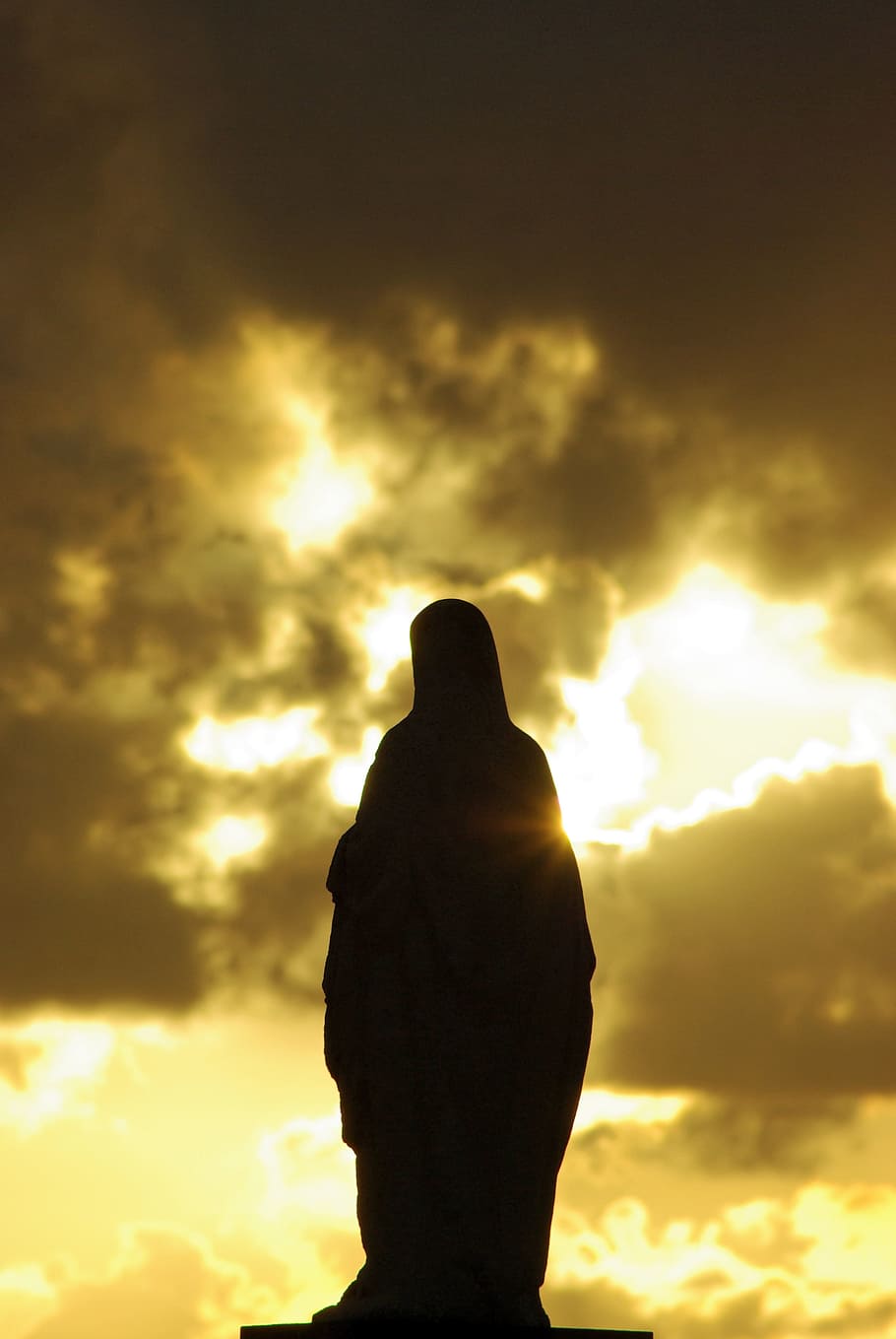 silhouette of Mother Mary statue under cloudy sky, virgin, cloud - sky