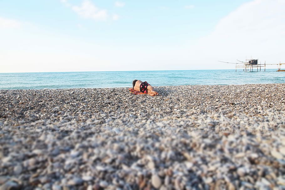 man lying on seashore, beach, seaside, rock, pebbles, ocean HD wallpaper