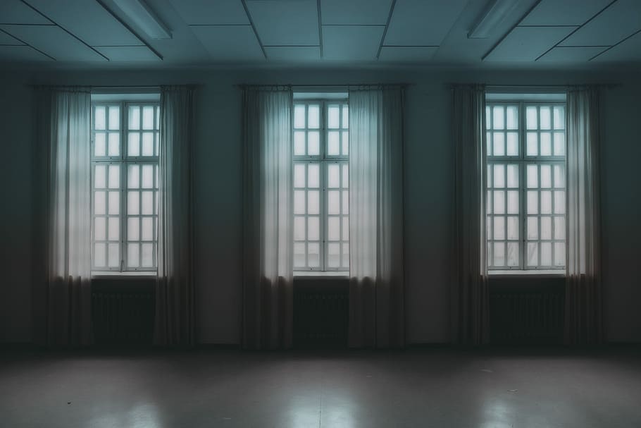 three open windows, windows with white curtains inside empty room