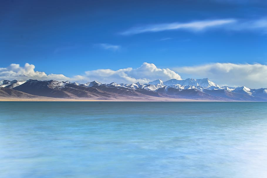 landscape photograph of mountains in front of bodywater, beach HD wallpaper