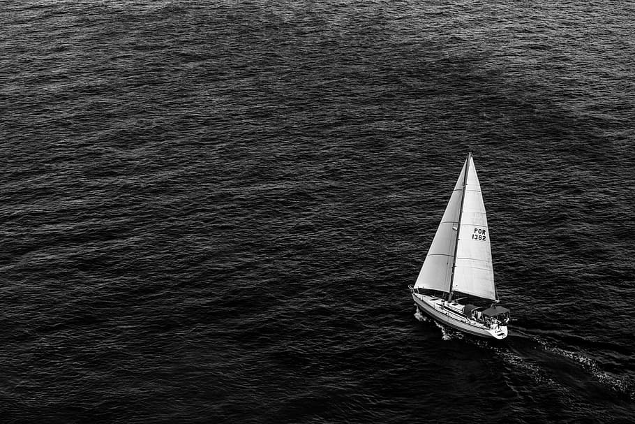 grayscale photography of sailing boat on body of water, white sailboat on body of water
