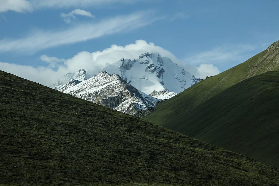 snow covered mountain, grass covered hills near glacier mountain during day HD wallpaper